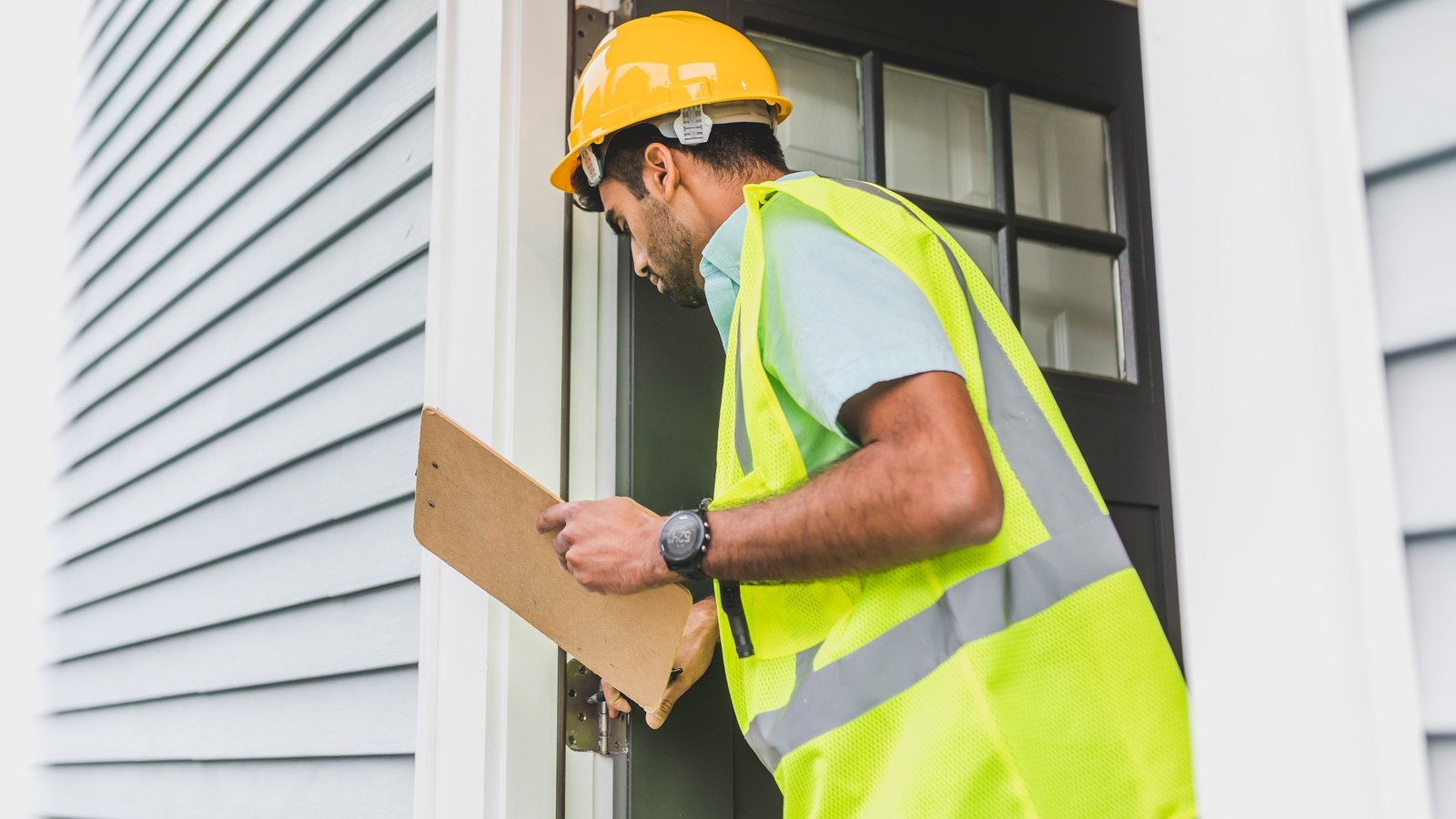 Home inspection professional evaluating exterior condition of a Calvert County Maryland house